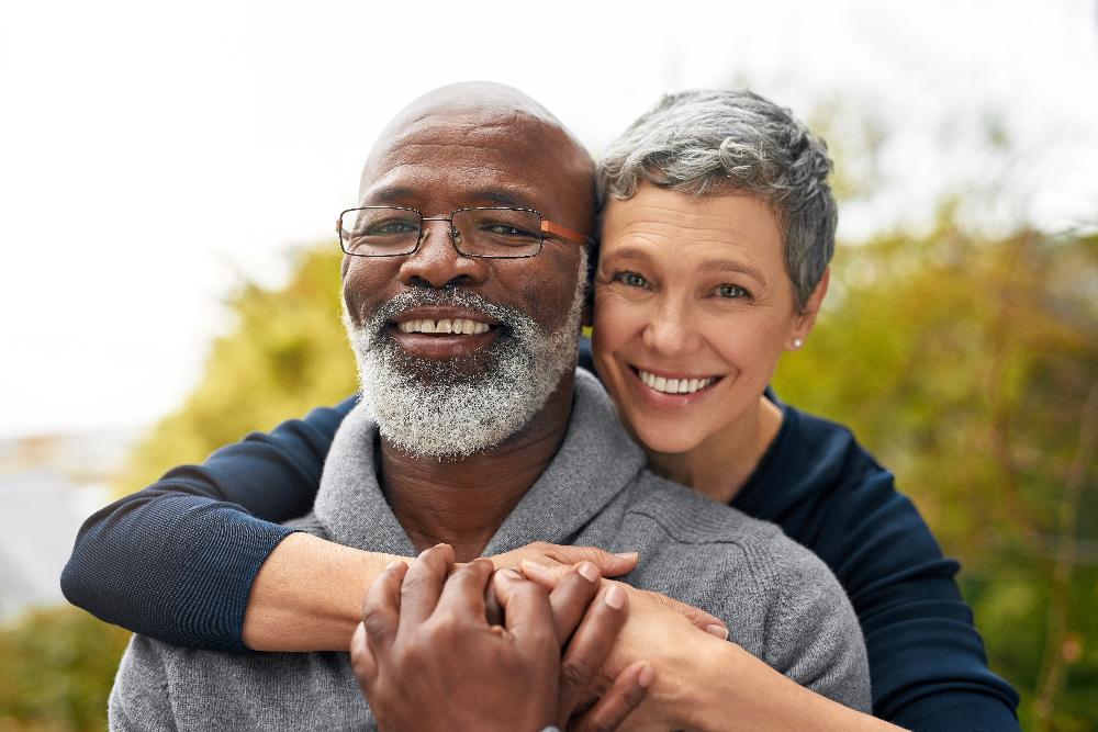 A joyful embrace between an older man and woman, highlighting their affection for each other.